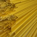 Detailfoto van ongekookte glutenvrije spaghetti, met goudgele pastaslierten en zichtbare uiteinden.