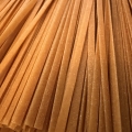 Close-up van lange, ongekookte biologische volkoren tagliatelle van Nonna di Sardegna, met brede goudbruine pastalinten naast elkaar. Kopieer